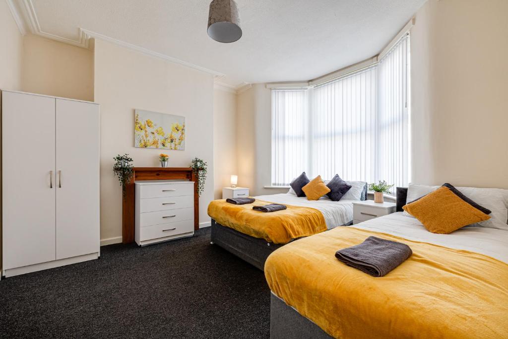 ein Schlafzimmer mit 2 Betten und einer Kommode darin in der Unterkunft Ursula Sparkle Stays in Liverpool