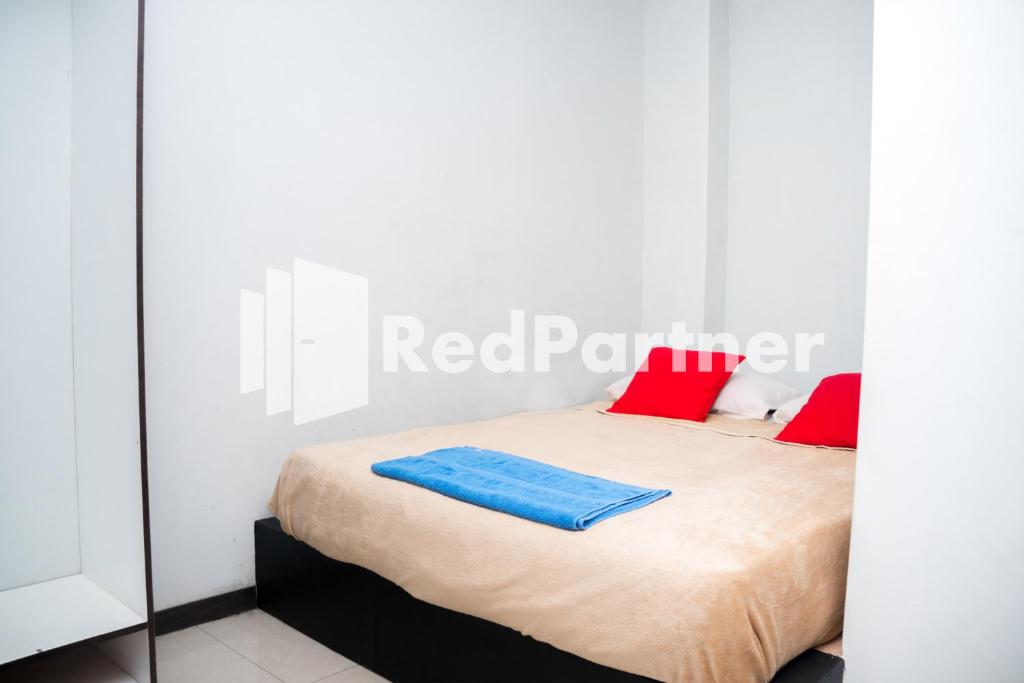 a bedroom with a bed with red pillows on it at Hotel C18 at Cibaduyut Mitra RedDoorz in Bandung