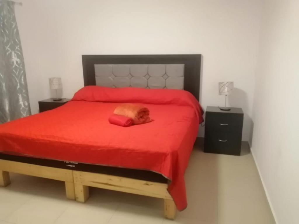 un perro tirado en una cama roja en un dormitorio en hermosa casa en coto privado especialmente para ti, 