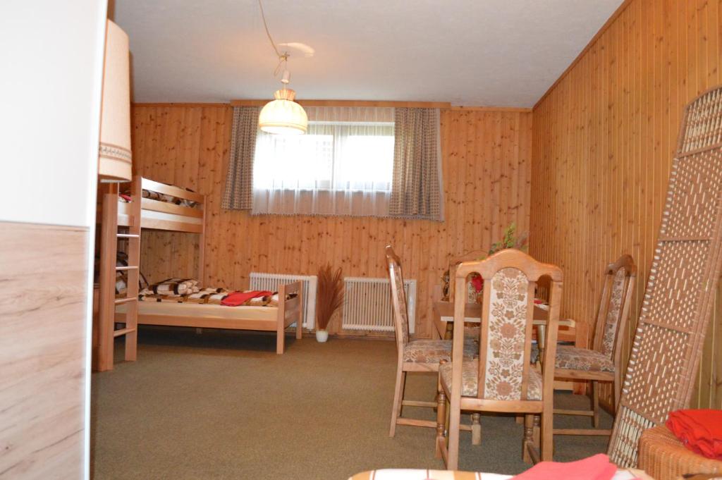 a room with wooden walls and a bedroom with a bunk bed at Apartman Kammleitn in Hermagor