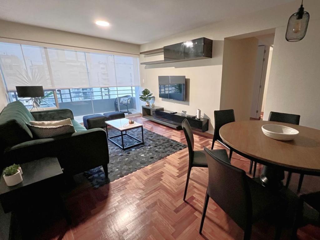 een woonkamer met een tafel en een bank bij MLA apartments - Alcanfores in Lima