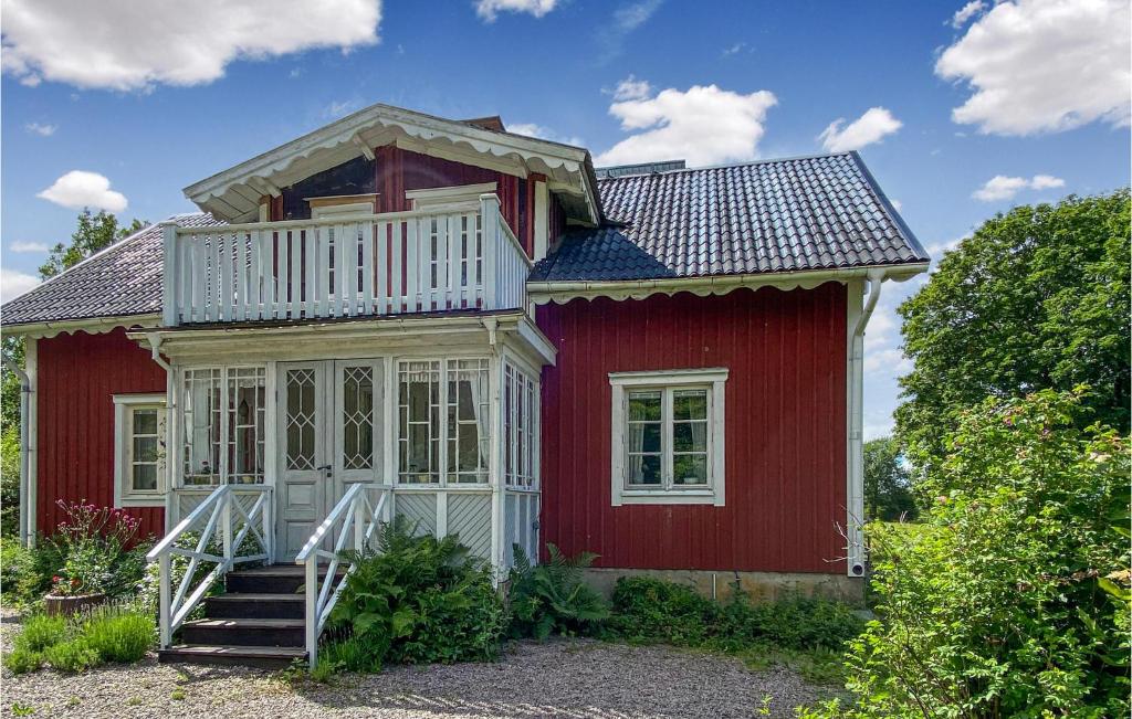 a red house with a white porch and stairs at Awesome Home In Trans With Kitchen in Tranås