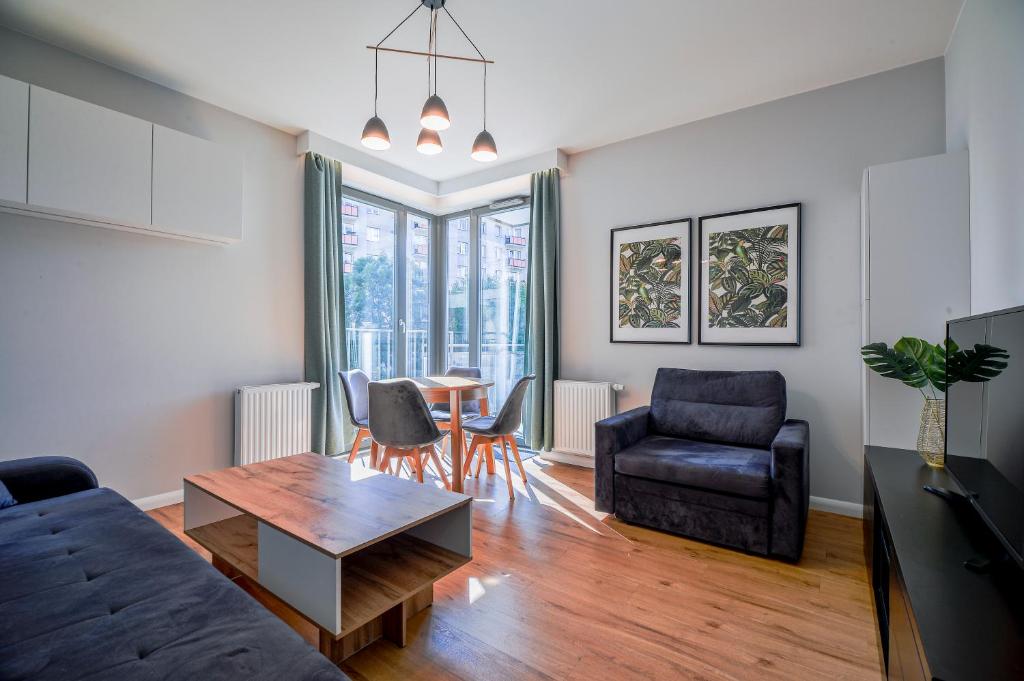 a living room with a couch and a table and chairs at CITYSTAY Garden Gates Apartment in Gdańsk