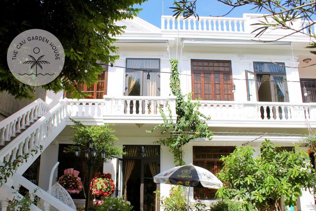 Casa blanca con barandilla blanca y balcón en The Cau Garden House, en Ấp Long Hồ Hạ