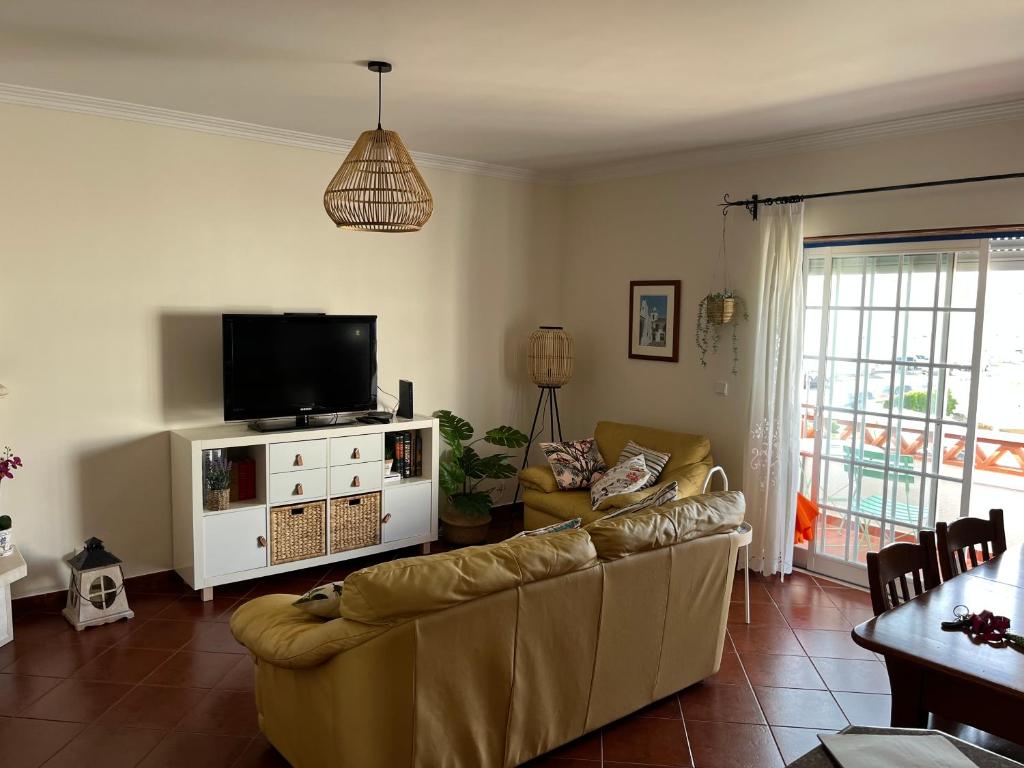 un soggiorno con divano e TV a schermo piatto di COZY APARTMENT ERICEIRA WITH SEA VIEW a Ericeira