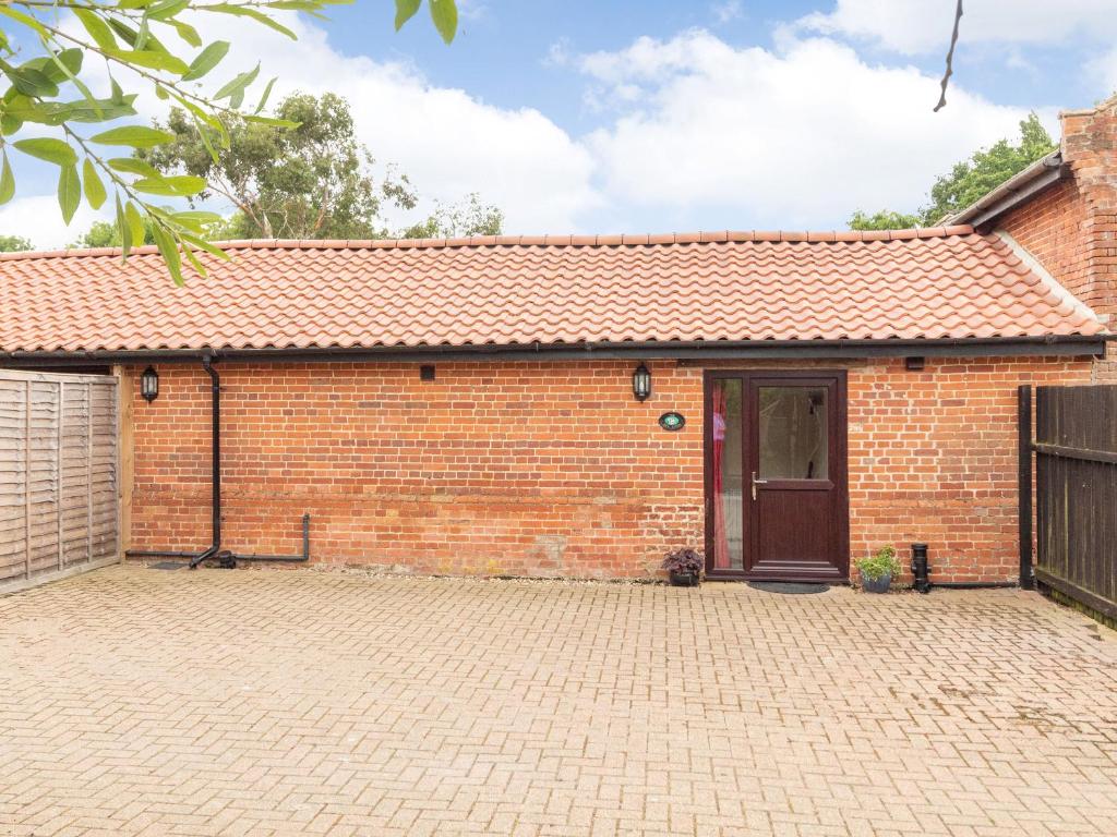 a brick building with a door and a brick driveway at The Hen House in Diss