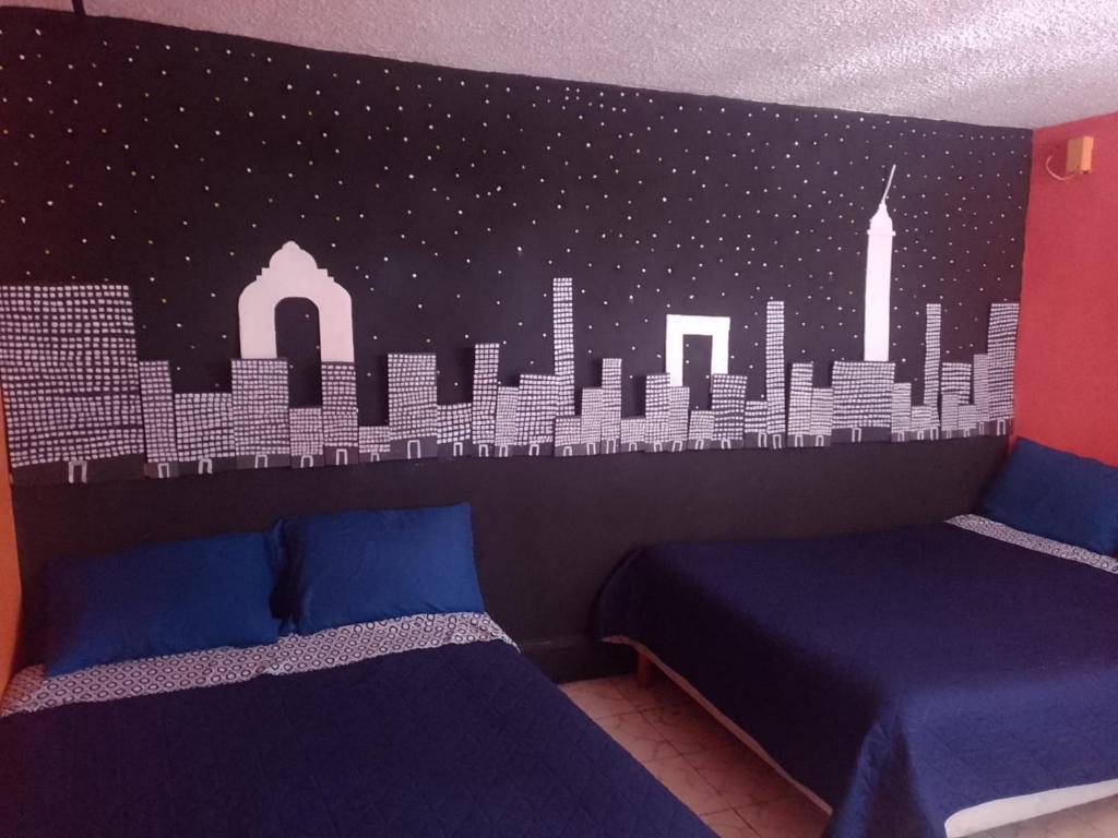 a bedroom with two beds and a mural of a city at Alo México in Mexico City
