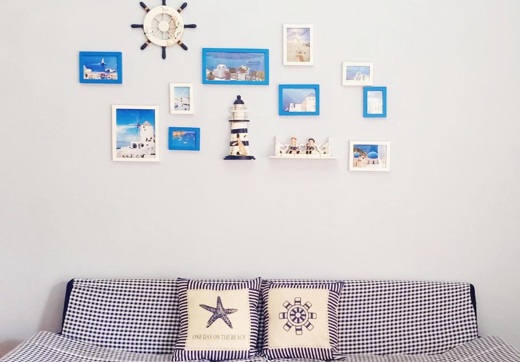 Sweet Home at Sattahip في ساتاهيب: غرفة معيشة مع أريكة وصور على الحائط
