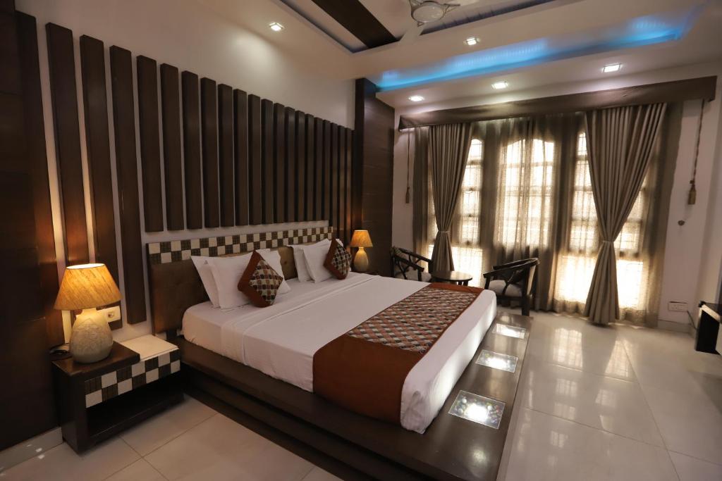 - une chambre avec un grand lit et une grande fenêtre dans l'établissement Mandakini villa, à New Delhi