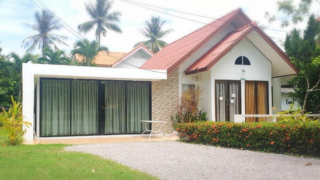 una pequeña casa blanca con techo rojo en Baan Golden Resort en Sam Roi Yot