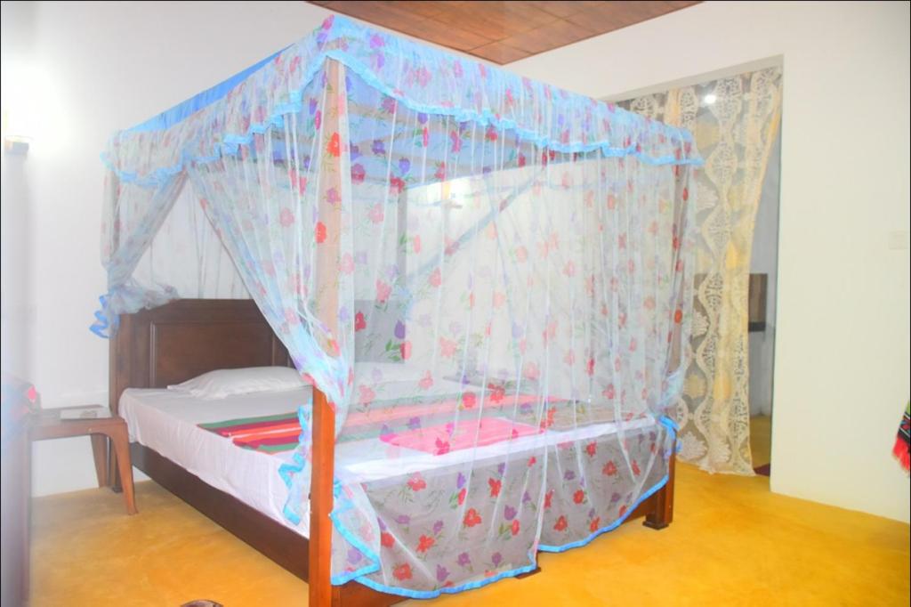 Cette chambre comprend un petit lit à baldaquin. dans l'établissement Jayanika Residence, à Tangalle