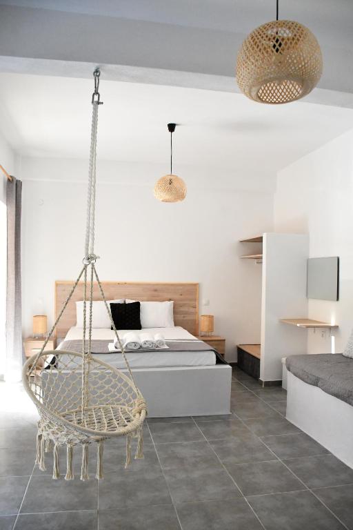 ein Schlafzimmer mit einem Bett und einer hängenden Schaukel in der Unterkunft Heliofos Apartments in Stomio