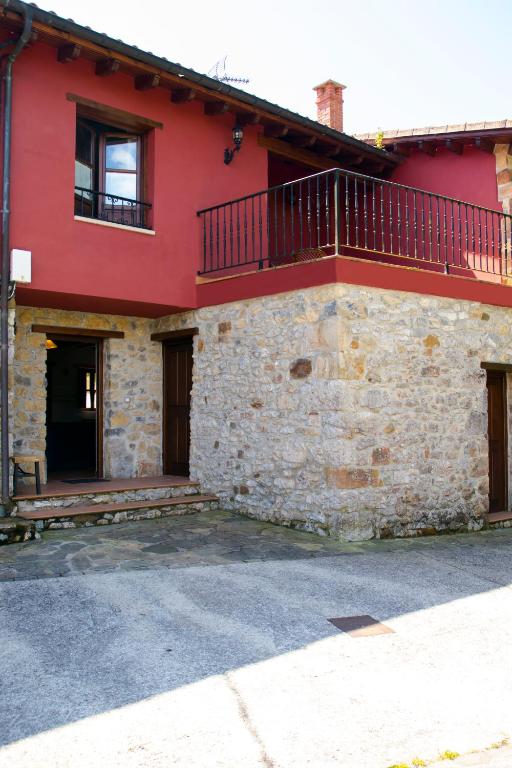 a red house with a balcony on the side of it at Casa Canela in Colladas