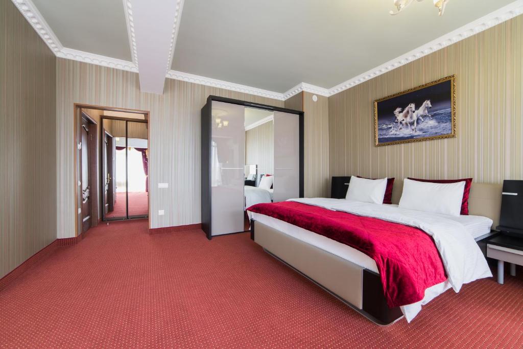 アドレルにあるANI Guest Houseの赤いカーペットフロアのベッドルーム1室(大型ベッド1台付)