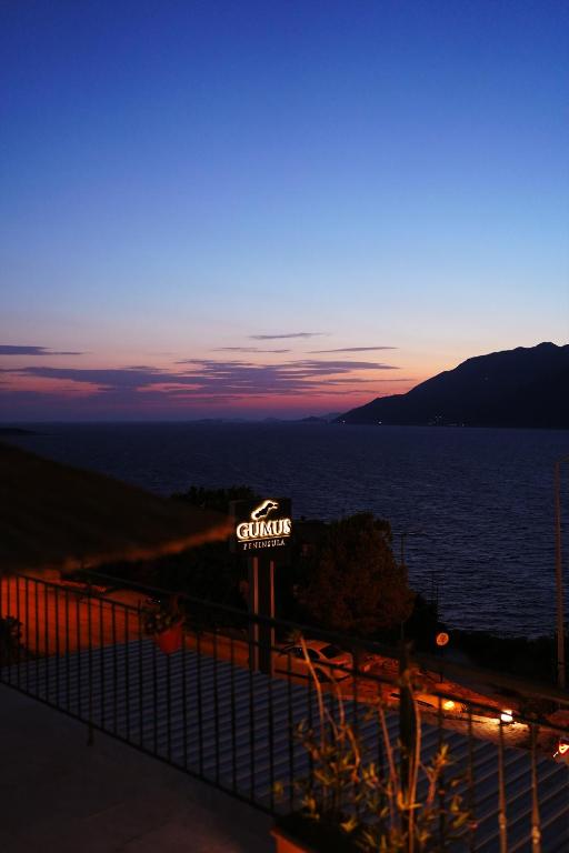 a sign for a gas station next to the water at Gümüş Yazar Hotel in Kaş