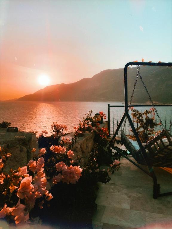 a swing with a sunset in the background at Gümüş Yazar Hotel in Kaş