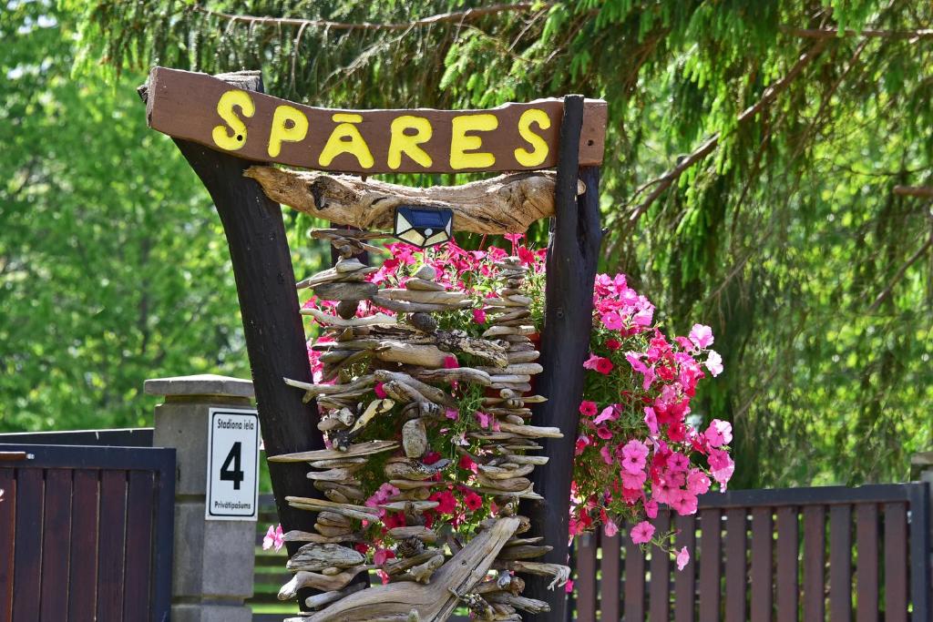 Ein Zeichen mit Pflanzen und Blumen. in der Unterkunft Lielās spāres in Pāvilosta