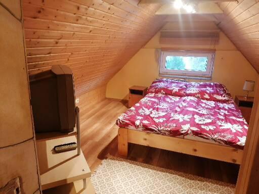 1 dormitorio pequeño con 1 cama y TV en Enjoy the silence en Rezi
