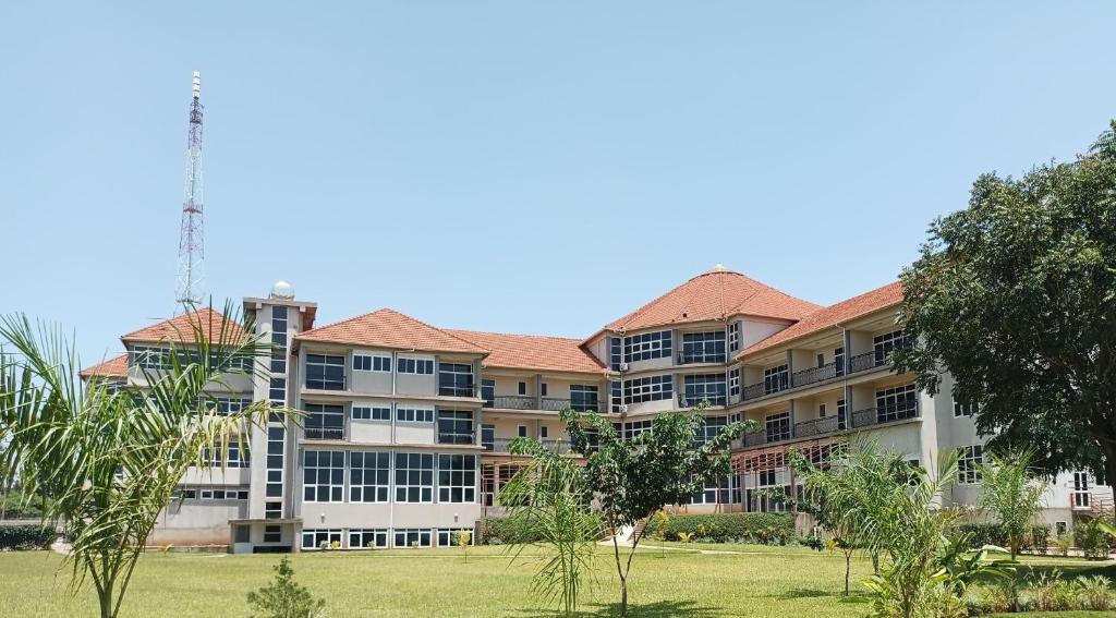 duży budynek apartamentowy z parkiem na pierwszym planie w obiekcie Mbale Courts View Hotel w mieście Mbale