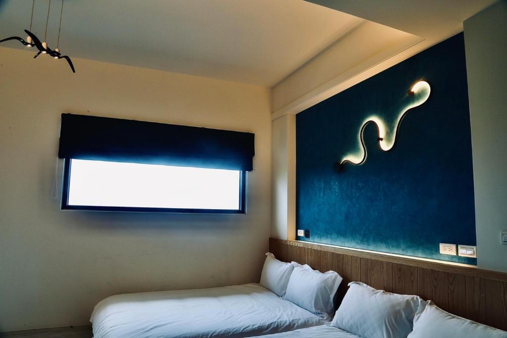 a room with a bed and a window and a window at Qian Qian Riverside B&B in Zhuangwei