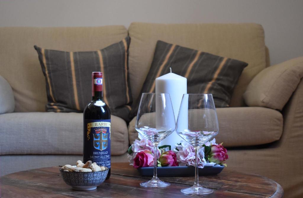 eine Flasche Wein und zwei Weingläser auf dem Tisch in der Unterkunft Appartamenti immersi nelle colline Toscane in Molino Mazzetti