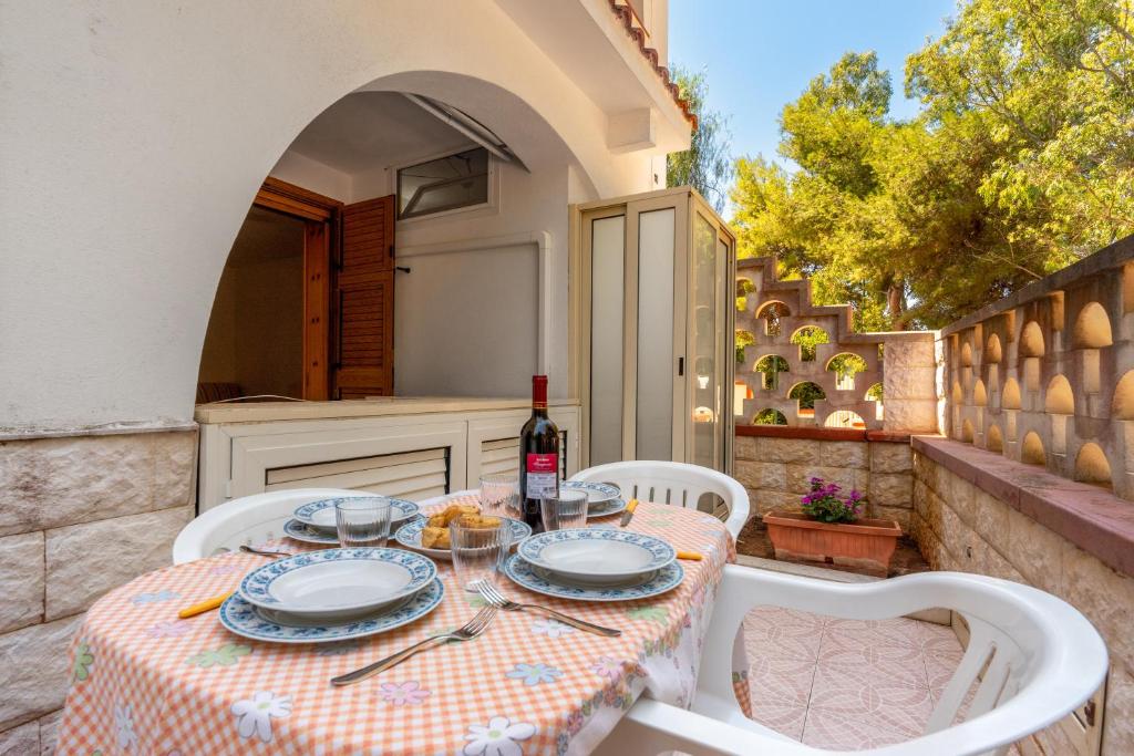 基諾沙的住宿－Bilocale Dimora Punta della Suina，餐桌,带食物盘和一瓶葡萄酒