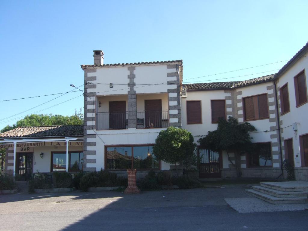 un bâtiment blanc avec une croix sur son côté dans l'établissement Hostal La Plata, à Oropesa