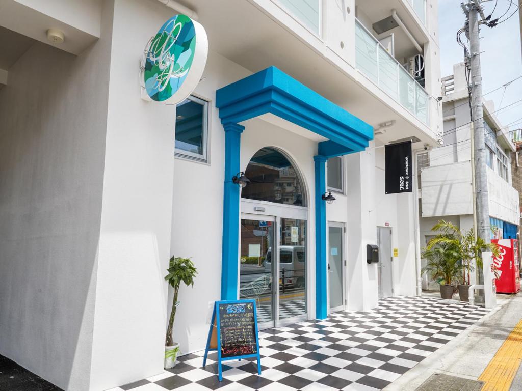 budynek z niebieskimi drzwiami i znakiem na szachowanej podłodze w obiekcie Glory island okinawa SOBE w mieście Naha