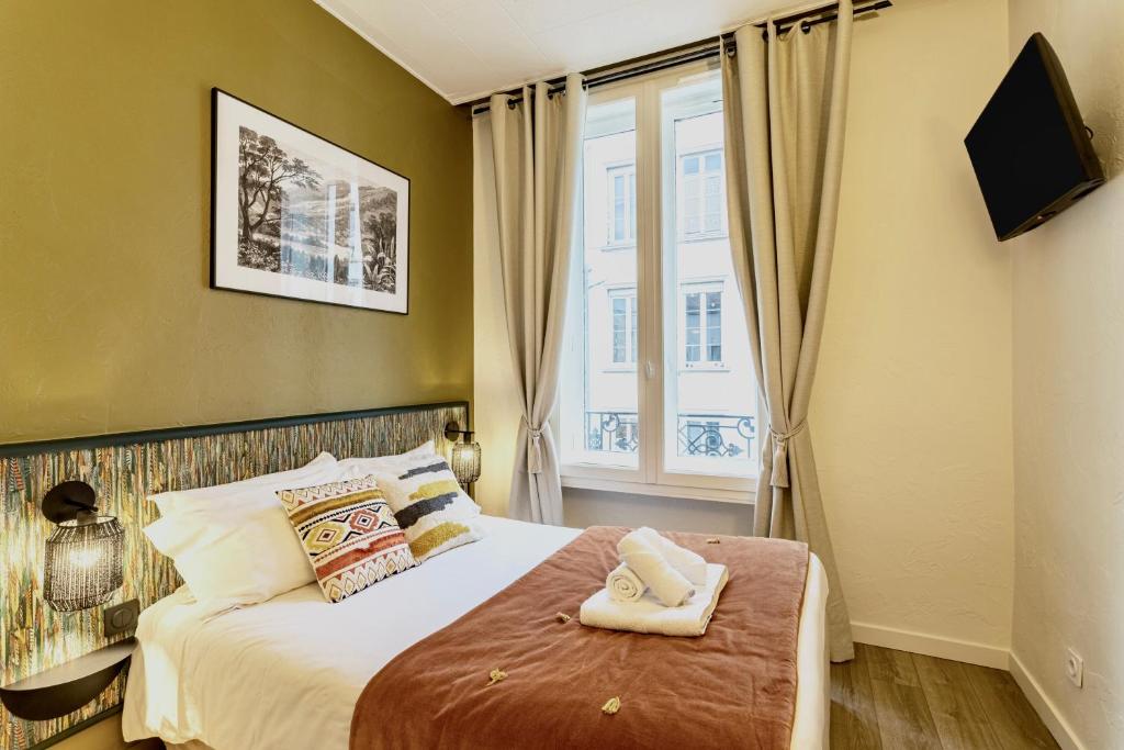 מיטה או מיטות בחדר ב-Hôtel Tête d'or