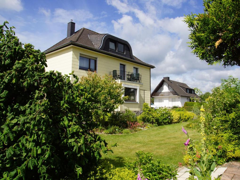 una casa amarilla con techo negro en Haus mit Garten (neben National Park Eifel), en Hürtgenwald