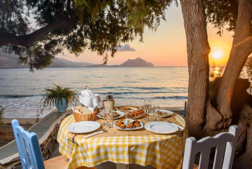 a table with food on it next to the ocean at Lakki Village in Aegiali