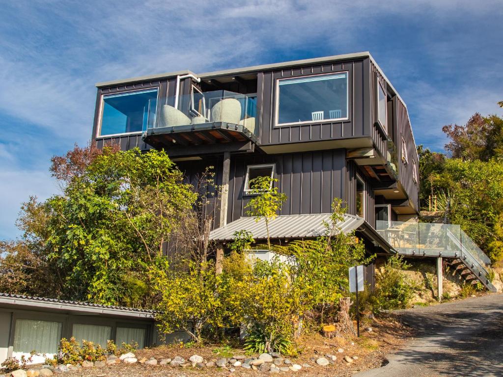 a house with a balcony on the side of a road at Roydons - Kaiteriteri Upstairs Holiday Unit in Kaiteriteri