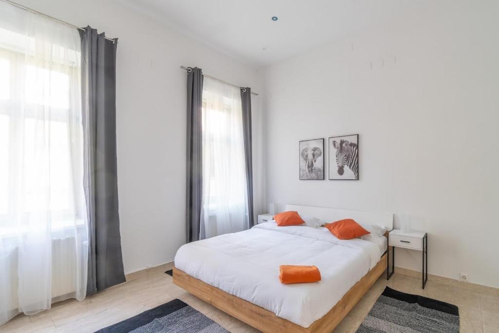 a bedroom with a bed with orange pillows on it at Centre Apartments in Vienna