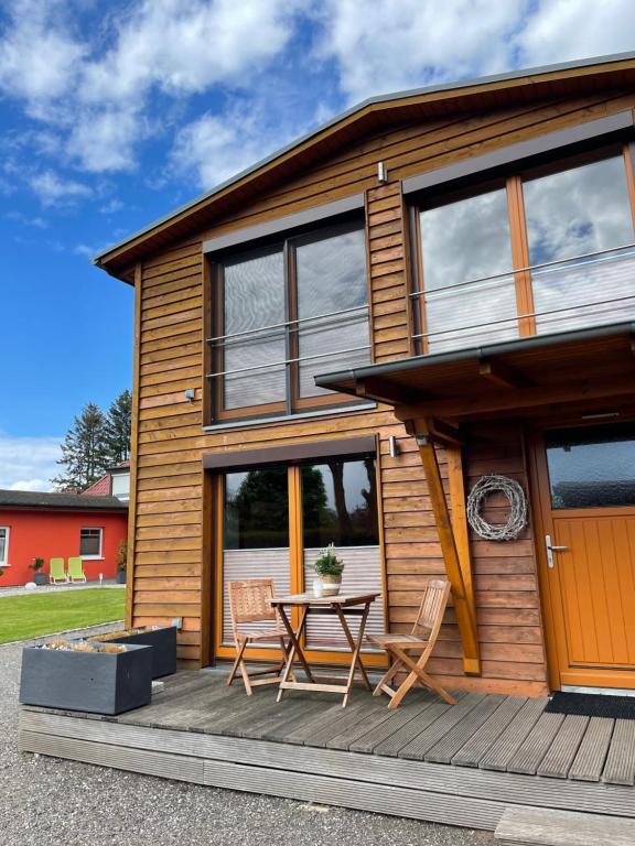a house with a table and chairs on a deck at Naturcamp Duvendiek Häuschen in Niepars