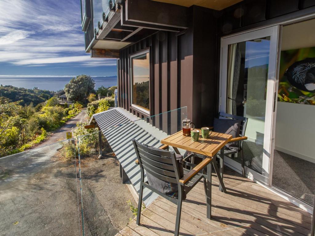 a wooden table on the balcony of a house at Roydon's Flat - Kaiteriteri Downstairs Unit in Kaiteriteri
