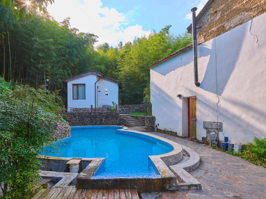 a swimming pool in a yard next to a building at July Bamboo Hostel in Deqing