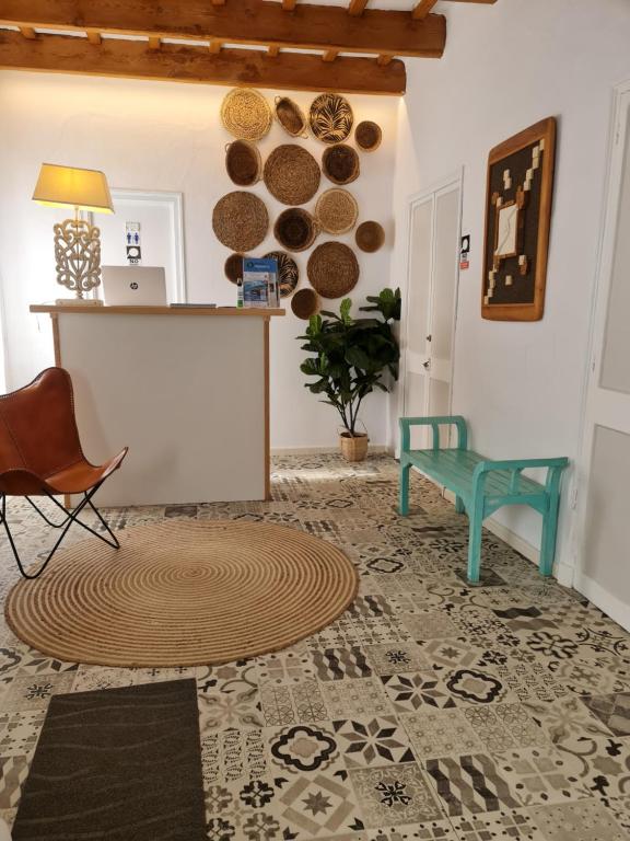 sala de estar con mesa, silla y alfombra en Habitaciones Casa de Campo Daymipaz en Mahón