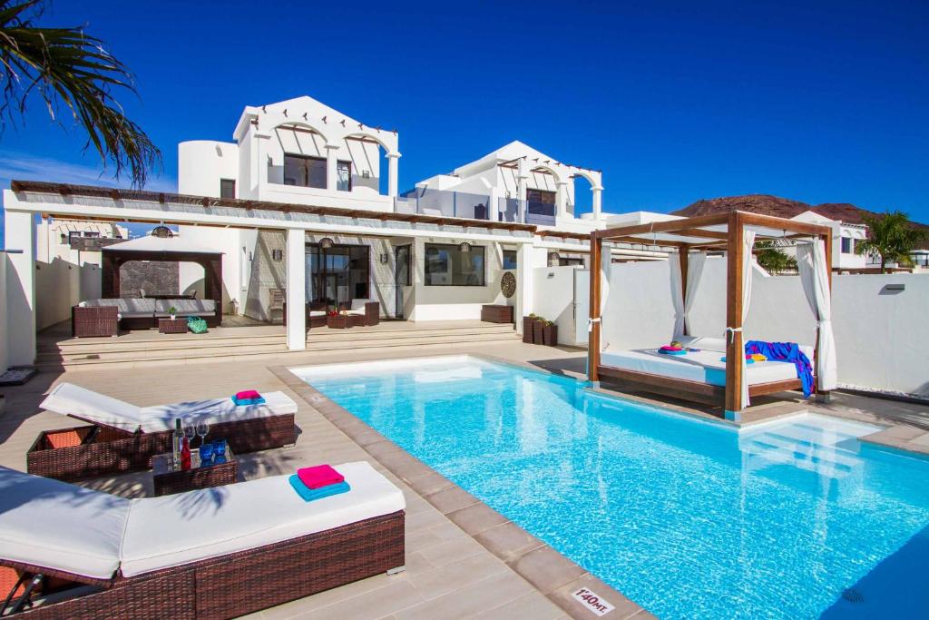 een villa met een zwembad en een huis bij Villa Pedro in Playa Blanca