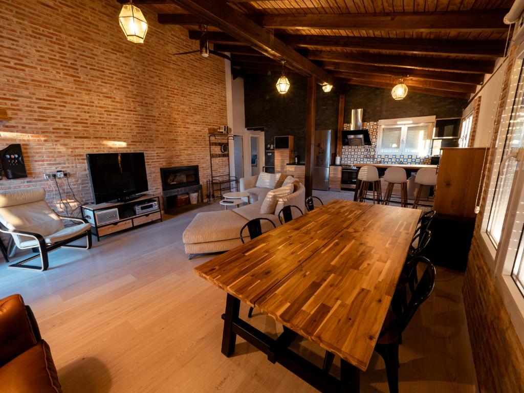 uma sala de estar com uma mesa de madeira e cadeiras em Casa Rural La Molina 4* em Navamorcuende