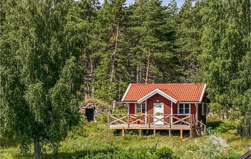 uma pequena cabana vermelha no meio de uma floresta em Stunning Home In Vikbolandet With Wifi And 2 Bedrooms 