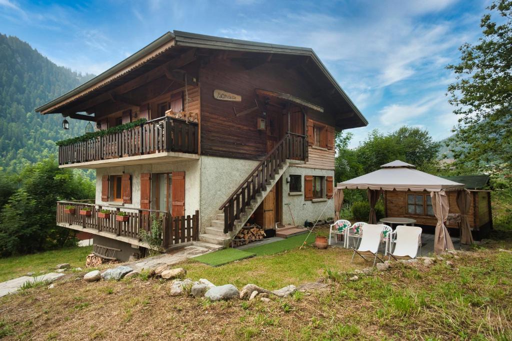 une maison avec un balcon, une table et des chaises dans l'établissement Appartement dans petit chalet, à Châtel