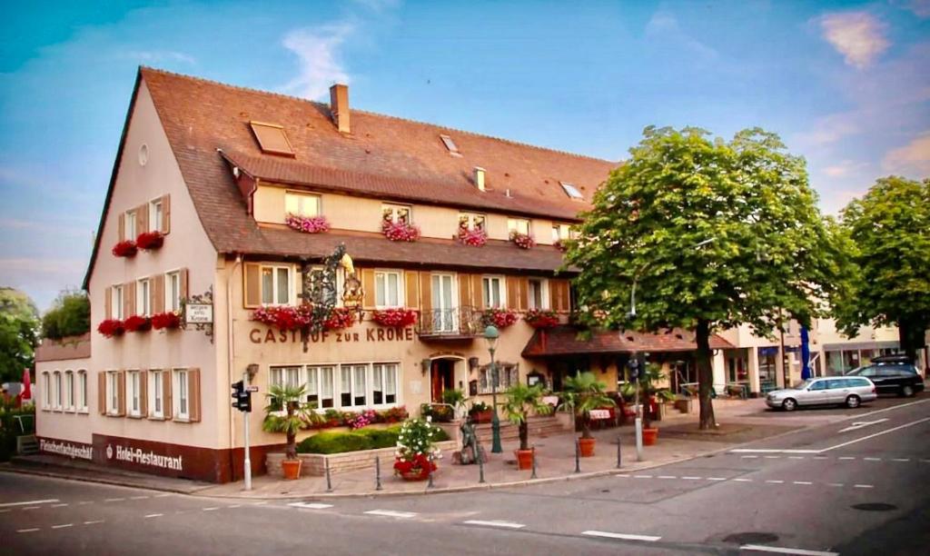 un grand bâtiment avec des fleurs en face d'une rue dans l'établissement Hotel Krone, à Neuenburg am Rhein