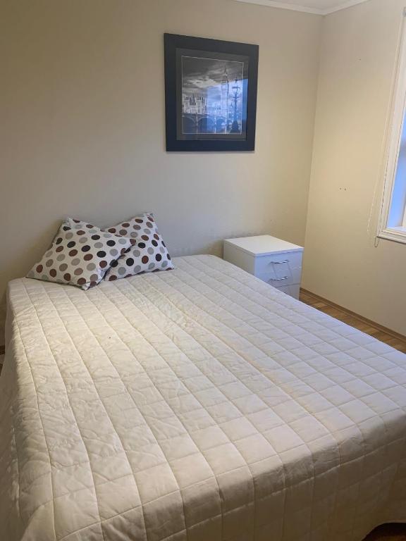 a bedroom with a bed and a picture on the wall at Bo i hjertet av Sunnmøre in Ålesund