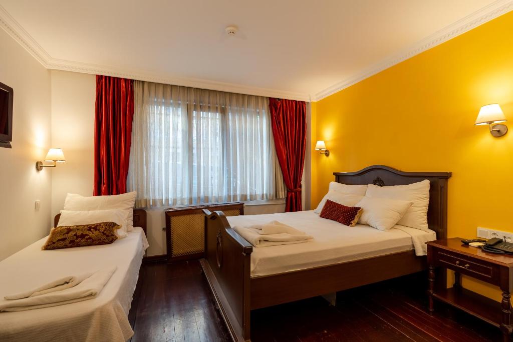 a hotel room with two beds and two lamps at Şebnem Hotel in Istanbul