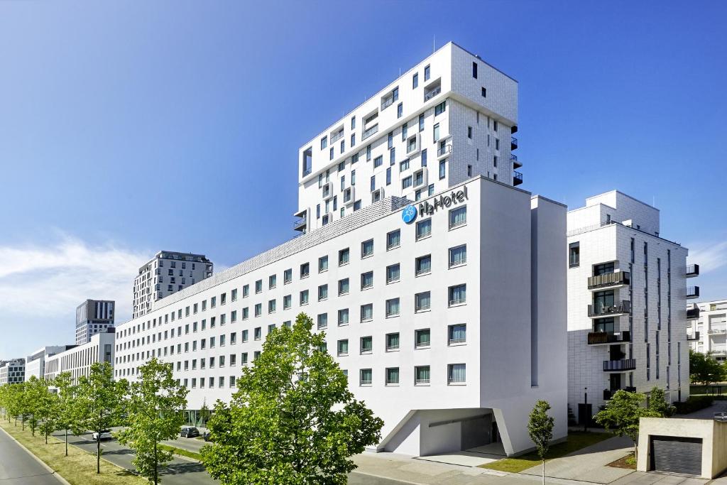 un edificio blanco con un cartel en el costado en H2 Hotel Düsseldorf City en Düsseldorf