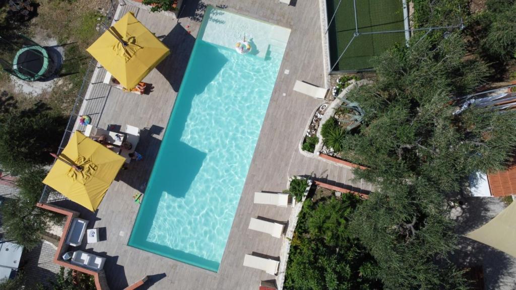 佩斯基奇的住宿－Villa di Pasquale，享有带遮阳伞的游泳池的顶部景致