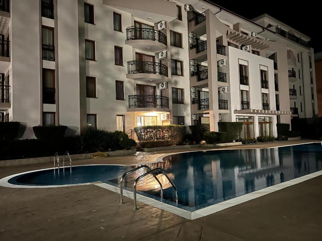 ein Hotel mit einem Pool vor einem Gebäude in der Unterkunft Alex Deluxe Apartments in Sonnenstrand