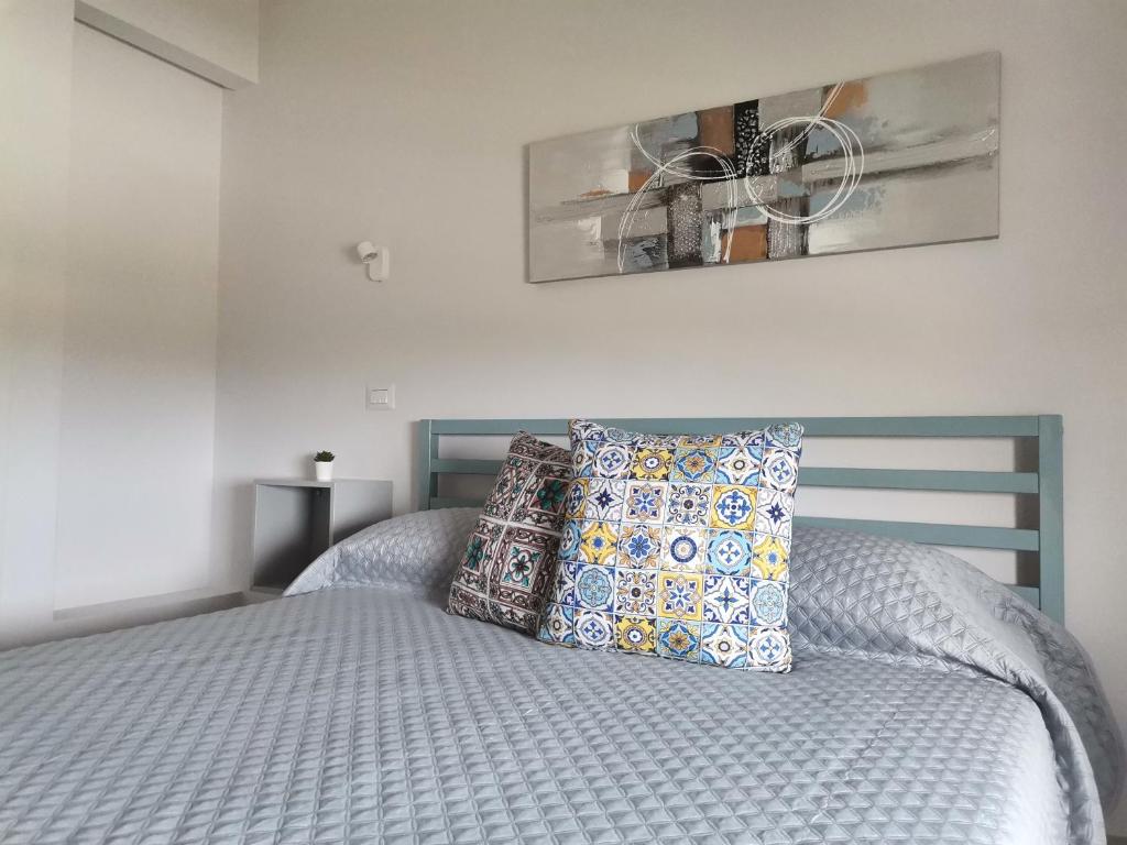 a bed with two pillows on it in a bedroom at Le Métro in Carini