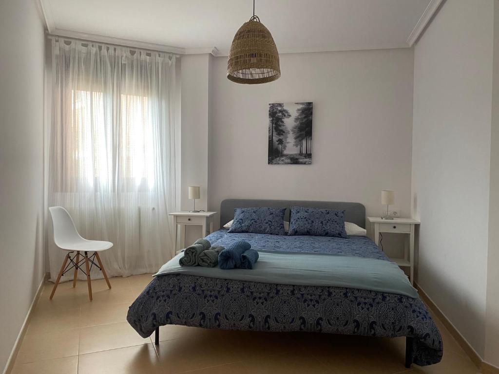 Un dormitorio con una cama y una silla dentro. en Apartamento El Valle de Aras. Bádames, en Bádames