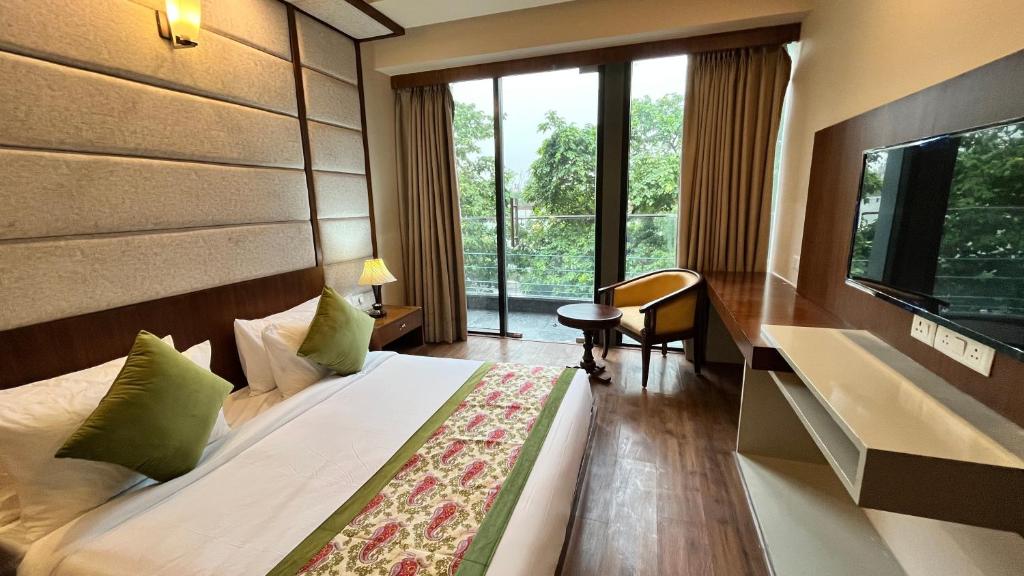 ニューデリーにあるIP Royal Hotel - Couple Friendly Near Yamuna Sports Complex, Karkardooma New Delhiのベッドと大きな窓が備わるホテルルームです。
